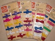 five assorted hair clips in plastic packaging on a table top with the package tagged down