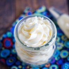 a jar filled with whipped cream sitting on top of a blue and red table cloth