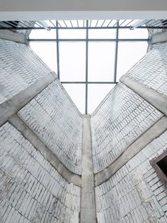 the inside of a building that has a skylight above it and brick walls on both sides