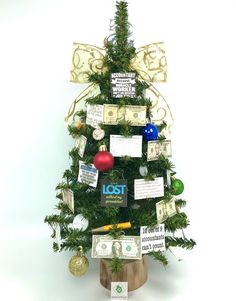 a small christmas tree decorated with money notes and other items on it's sides