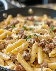 a skillet filled with pasta, meat and parmesan cheese