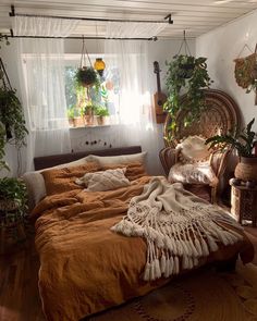 a bed sitting in a bedroom next to a window with plants on top of it