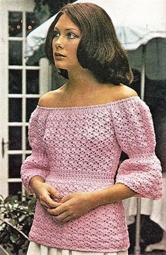 a woman wearing a pink crocheted sweater