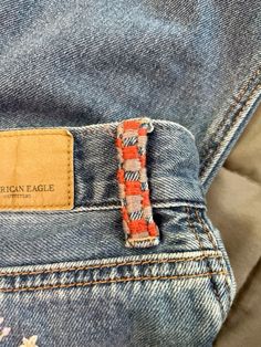 an orange and white striped tie is in the pocket of a pair of blue jeans