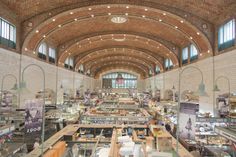 the inside of a large building with lots of tables and chairs in it's center