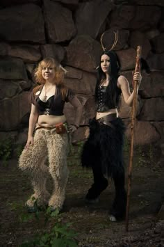 two women dressed up in costumes standing next to each other with horns on their heads