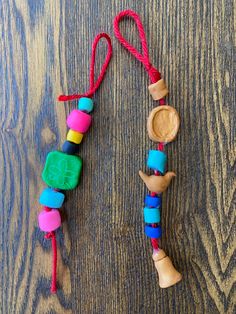 a wooden bead necklace on a table with a spoon and some beads attached to it