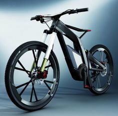 an electric bike is shown in front of a gray background with light coming from behind it