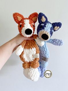 two crocheted stuffed animals are being held by someone's hand in front of a white wall