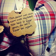 a teddy bear with a message attached to it's back sitting on a plaid pillow