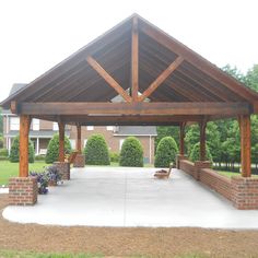 a covered patio with brick pillars and benches