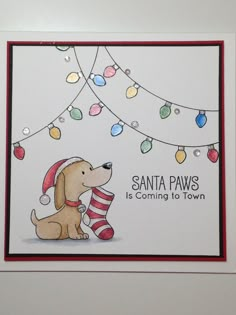 a card with a dog holding a christmas stocking on it's nose and saying santa paws is coming to town