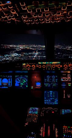 the view from inside an airplane at night with lights on and control panels lit up