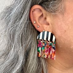 These earrings are all about movement! Features a unique half moon stud in a striking black and white stripe acrylic with a contrasting flirty fringe detail in a hand-swirled acrylic mix of all the colors in the rainbow; red, orange, yellow, green, blue, white and pink.  Designed for Closet Rehab. Handmade in Pittsburgh, PA. Made in the USA. Materials: acrylic, brass base posts/jump rings with 18k gold plating Hypoallergenic  Our accessories are handcrafted from colorful acrylic. To preserve you White Fringe Earrings, Jump Ring Earrings, Colors In The Rainbow, September Birthstone Jewelry, White Fringe, July Birthstone Jewelry, August Birthstone Jewelry, Moon Studs, Mini Hoop Earrings