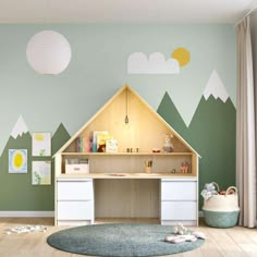 a child's room with mountains painted on the wall and a desk in the corner