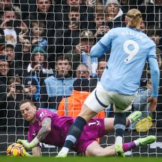 the soccer player is diving to save the ball from going into the goalie's net