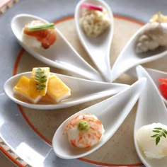 there are many different types of sushi on the plate with spoons in it