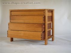 a wooden dresser sitting on top of a white floor