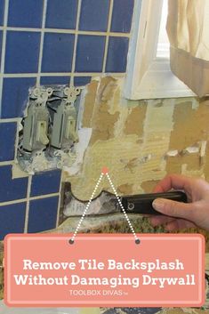 a person removing tile from a bathroom wall with a pair of scissors and a tool