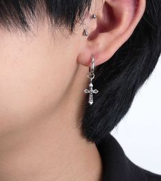 a close up of a person's ear with a cross on the back of it