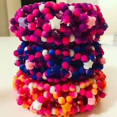 a stack of multicolored bracelets sitting on top of a table