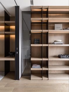 an open book shelf with many books on it in a room that has wooden shelves