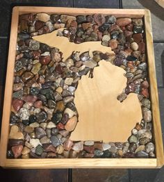 a wooden table with rocks in the shape of michigan on it and a piece of wood that has been cut out