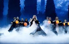 a group of people standing on top of a fog covered field with orange balls in their hands