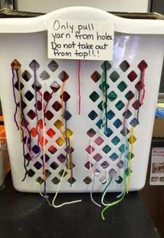 an office cubicle with several different colored crochet hooks attached to it