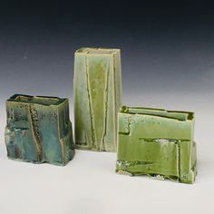 three green vases sitting next to each other on a table