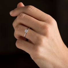 a woman's hand with a diamond ring on it