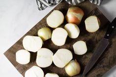 chopped onions are on a cutting board next to a knife and striped dish cloths