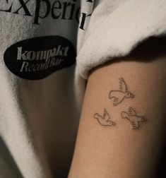 a woman with a tattoo on her arm that reads komaka records and two doves