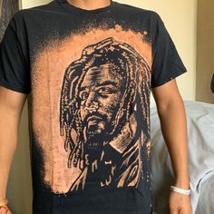 These are J. Cole t-shirts that I handpainted with bleach! These are on a Gildan brand black t-shirt, 100% cotton. I painted these by hand. This t-shirt is perfect for his upcoming tour, or any music festival. Slide to the last photo for sizing information! If you have any questions, please contact me! *Every t-shirt is handmade which means there will be a slight variation from photos* *Model is 5'7, 150 pounds, muscular build and is wearing size L  Instagram~ @artbyzahide Twitter~ @artbyzahide Jack Harlow T Shirt, Bleached Black T-shirt For Streetwear, Casual Black T-shirt With Custom Artwork, Streetwear Bleached Graphic Tee T-shirt, Bleached Band Merch T-shirt For Streetwear, Black Bleached Graphic Tee T-shirt, Black Bleached T-shirt For Streetwear, Black Bleached Graphic Tee, J Cole T Shirt