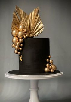 a black cake with gold decorations on top