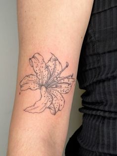 a woman's arm with a flower tattoo on the left side of her arm