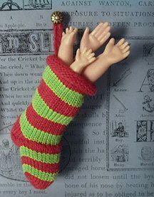 a knitted christmas stocking ornament with hands coming out of the top