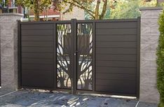 a gate that is in the middle of a concrete block wall and surrounded by trees