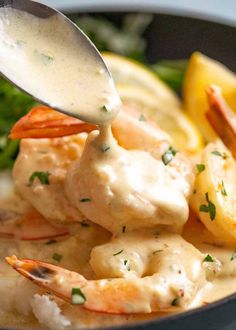 a spoon scooping some food out of a bowl with shrimp and broccoli