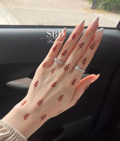 a woman's hand with red leaves on it