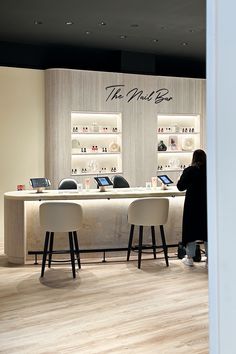 a woman standing in front of a counter with laptops on it