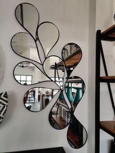 a mirror hanging on the side of a wall next to a black and white vase