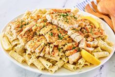 a white plate topped with pasta and chicken