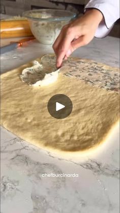 a person is kneading dough on top of a counter