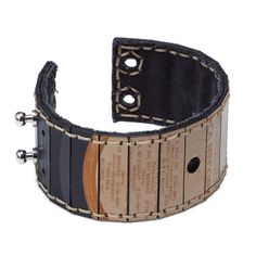 a leather bracelet with wooden strips and metal fittings on the ends, decorated with black stitching