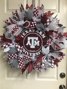 the texas a & m university wreath is hanging on a door with red and white ribbons