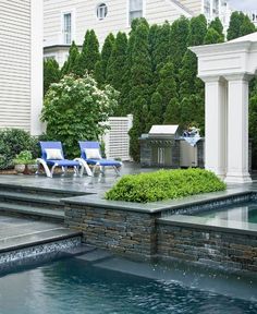 an outdoor pool with lounge chairs next to it