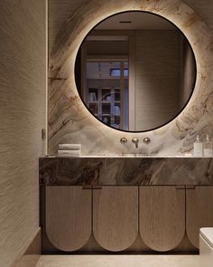 a bathroom with a round mirror above the sink and marble counter tops on the wall