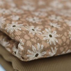 the fabric is brown and white with daisies on it's sides, as well as flowers