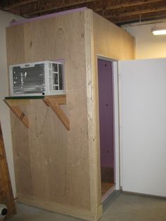 an air conditioner mounted on the side of a wall in a room under construction